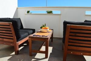 dwa krzesła i stół z miską pomarańczy. w obiekcie Comfortable Apartment in Torre de la Horadada w mieście Torre de la Horadada