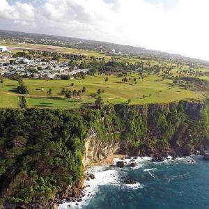 una vista aerea su un campo da golf su una scogliera vicino all'oceano di Beautiful Villa 5 mins from Crash Boat Aguadilla 1 ad Aguadilla