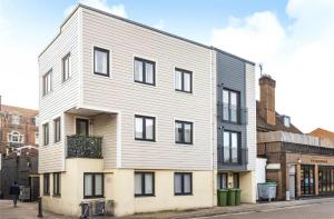 a white building with black windows on a street at No.1 Universal House - Double Bedroom Apartment in Bromley