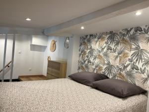 - une chambre avec un grand lit et du papier peint tropical dans l'établissement La Ciotat vieux port 2, à La Ciotat