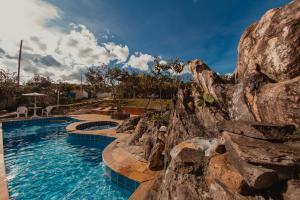 a pool at a resort with a rock wall at SO HAM Guest House in Diamantina