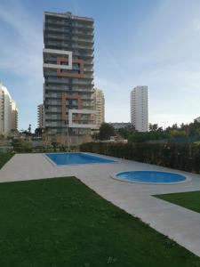 a swimming pool in a park with a tall building at Cool Residence in Portimão