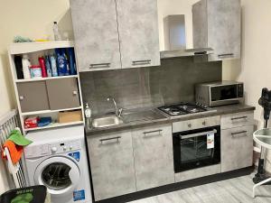 cocina con fregadero y lavadora en KAM DELUXE Rooms And Home Vacancy, en Calamonaci