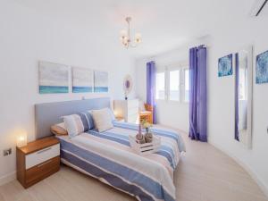 - une chambre dotée d'un lit avec des draps bleus et blancs dans l'établissement Apartment on Beach Mijas 2, à Sitio de Calahonda