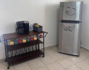 a kitchen with a refrigerator and a shelf with drinks at Beautiful Villa 5 mins from Crash Boat Aguadilla 1 in Aguadilla