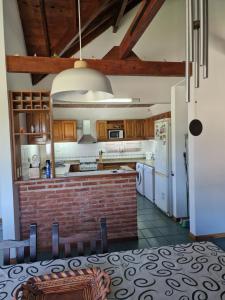 una cucina con elettrodomestici bianchi e un muro di mattoni di Dunas Chalet y Apartamento a Pinamar