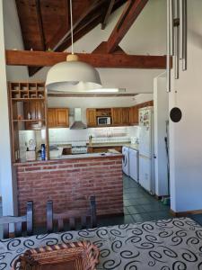 a kitchen with white appliances and a brick wall at Dunas Chalet y Apartamento in Pinamar