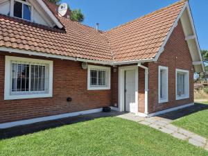 una casa de ladrillo con techo rojo en Dunas Chalet y Apartamento en Pinamar