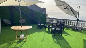patio z krzesłami, stołem i parasolem w obiekcie Slice of ponta do sol Room 1 w mieście Ponta do Sol