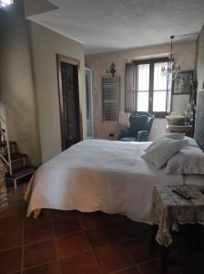 a bedroom with a large white bed and a chair at La torre della manca suite in Sasso di Castalda