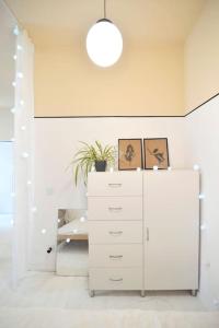 Zimmer mit einem weißen Schrank und einer Topfpflanze in der Unterkunft Big Retro (PRL) Apartment City Center - Old Town in Breslau