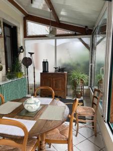 uma sala de jantar com uma mesa de madeira e cadeiras em maison de campagne em Trézelles