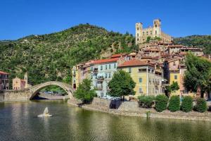 una piccola barca in un fiume con un ponte di Appartamentino - Castle view, no stairs a Dolceacqua