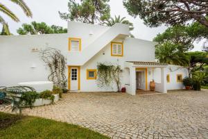 een wit huis met gele accenten bij Maria Lisboa in Almancil