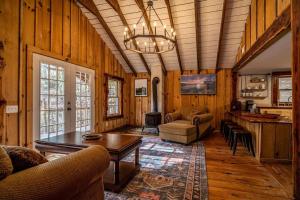 a living room with wood paneling and a table and chairs at Hike the Holler - Stay & Explore in Cosby