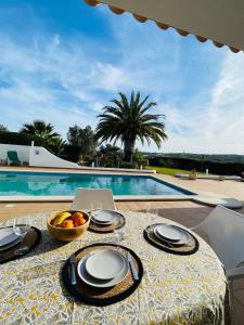 una mesa con un bol de fruta y un ordenador portátil. en Villa Serro das Vinhas en Portimão