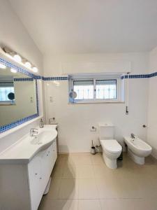 uma casa de banho com um lavatório, um WC e um espelho. em Villa Serro das Vinhas em Portimão
