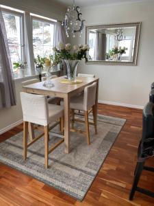 una mesa de comedor con sillas y un jarrón de flores en Casa la Familia en Bergen