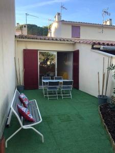 un patio con sillas y una mesa en una casa en Joli appartement à proximité du village naturiste en Cap d'Agde