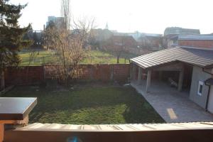 einen Hinterhof mit einem Zaun und einem Garten mit Gras in der Unterkunft Moderan apartman Ana - Vinkovci centar in Vinkovci