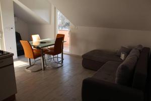 ein Wohnzimmer mit einem Sofa, einem Tisch und Stühlen in der Unterkunft Moderan apartman Ana - Vinkovci centar in Vinkovci