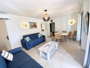 salon z niebieską kanapą i stołem w obiekcie Appart spacieux ,lumineux ,proche des plage , piscine w mieście Les Issambres