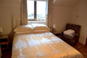sypialnia z łóżkiem, krzesłem i oknem w obiekcie Holiday home in Falcarragh, Gortahork, Donegal w mieście Falcarragh