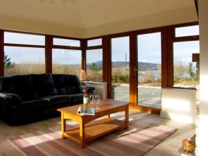 a living room with a black couch and a table at Holiday home in Falcarragh, Gortahork, Donegal in Falcarragh