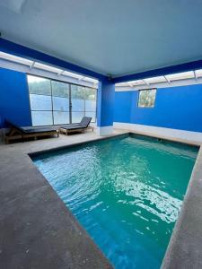 una gran piscina en una habitación azul en Departamento Frente a Espacio Grecia, Calama., en Calama