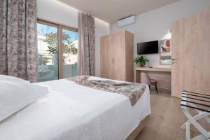Un dormitorio con una cama y un escritorio y una ventana. en Rosa’s luxury apartment, en Cos