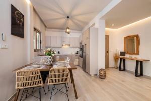Una cocina y una sala de estar con mesa y sillas. en Rosa’s luxury apartment, en Cos