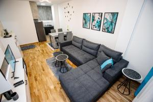uma sala de estar com um sofá e uma mesa em Tik Tak apartman em Subotica