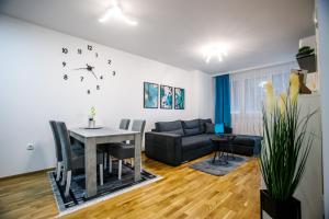 uma sala de estar com uma mesa e um sofá em Tik Tak apartman em Subotica