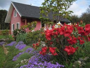 una casa rosa con flores delante en Casa Viña en Valdivia