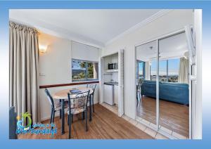 a room with a table and a bathroom with a tub at Marina views at Airlie 10H in Airlie Beach