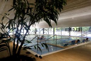 a pool in a building with people in the water at Apartamento do Castelo in Melgaço
