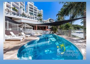a swimming pool in front of a building at Marina views at Airlie 10H in Airlie Beach