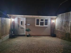 una casa con una porta e un patio in mattoni di notte di The Patch a Brighton & Hove