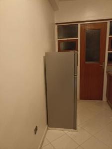 a kitchen with a refrigerator in the corner of a room at Rabat, Appartement Neuf en face d'Arribat Center. in Rabat
