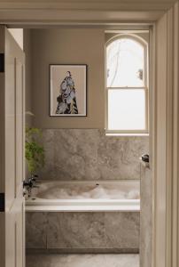 e bagno con finestra e vasca. di Leighton House - Boutique Guesthouse a Bath