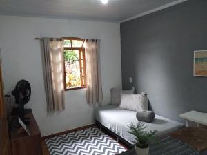 a bedroom with a bed and a window at Casa com vista para o mar em Paraty in Paraty