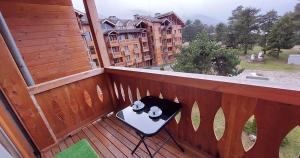 a balcony with a table and two mugs on it at Сладко студио в Пирин с голф и СПА комплекс in Razlog +51 photos