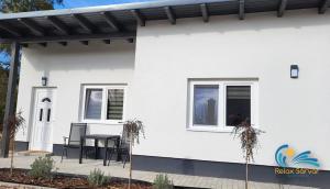 a white house with a table and chairs on a patio at Relax Apartmens Sárvár A3 in Sárvár +1 photo