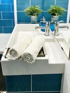 a bathroom sink with two rolled towels on it at Casa Tortilla Sagrada Familia in Barcelona