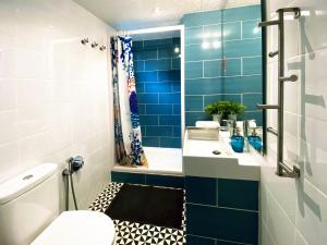 Un baño azul con lavabo e inodoro. en Casa Tortilla Sagrada Familia, en Barcelona 27 fotos más