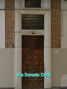 una puerta marrón en un edificio con ventana en Via Creti & Via Mazza Rooms en Bolonia