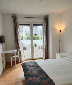 sypialnia z łóżkiem i przesuwnymi szklanymi drzwiami w obiekcie 理想方向 w Lizbonie