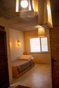 niewielka sypialnia z łóżkiem i oknem w obiekcie Hotel Tulmas w mieście Tilcara