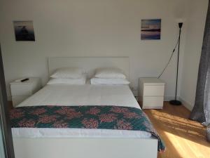 sypialnia z białym łóżkiem i 2 szafkami nocnymi w obiekcie 理想方向 w Lizbonie