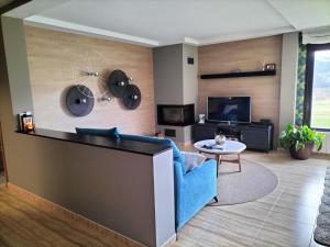 ein Wohnzimmer mit einem blauen Sofa und einem TV in der Unterkunft Leku eder in Areatza